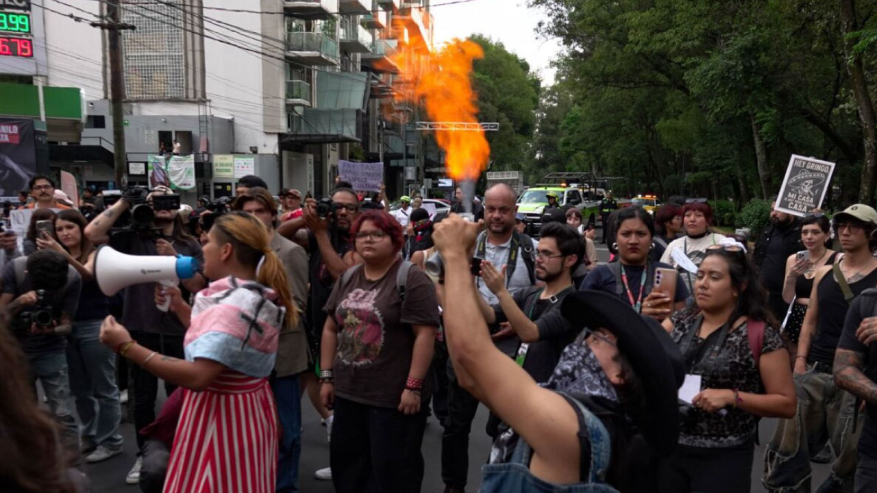 Manifestantes con pancartas frente a un Starbucks vandalizado en la colonia Condesa.  