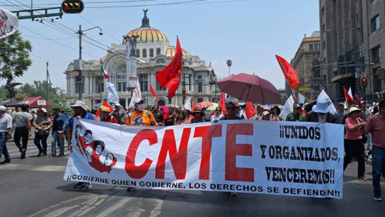 Maestros de la CNTE marchan en el Centro Histórico de la CDMX con pancartas.