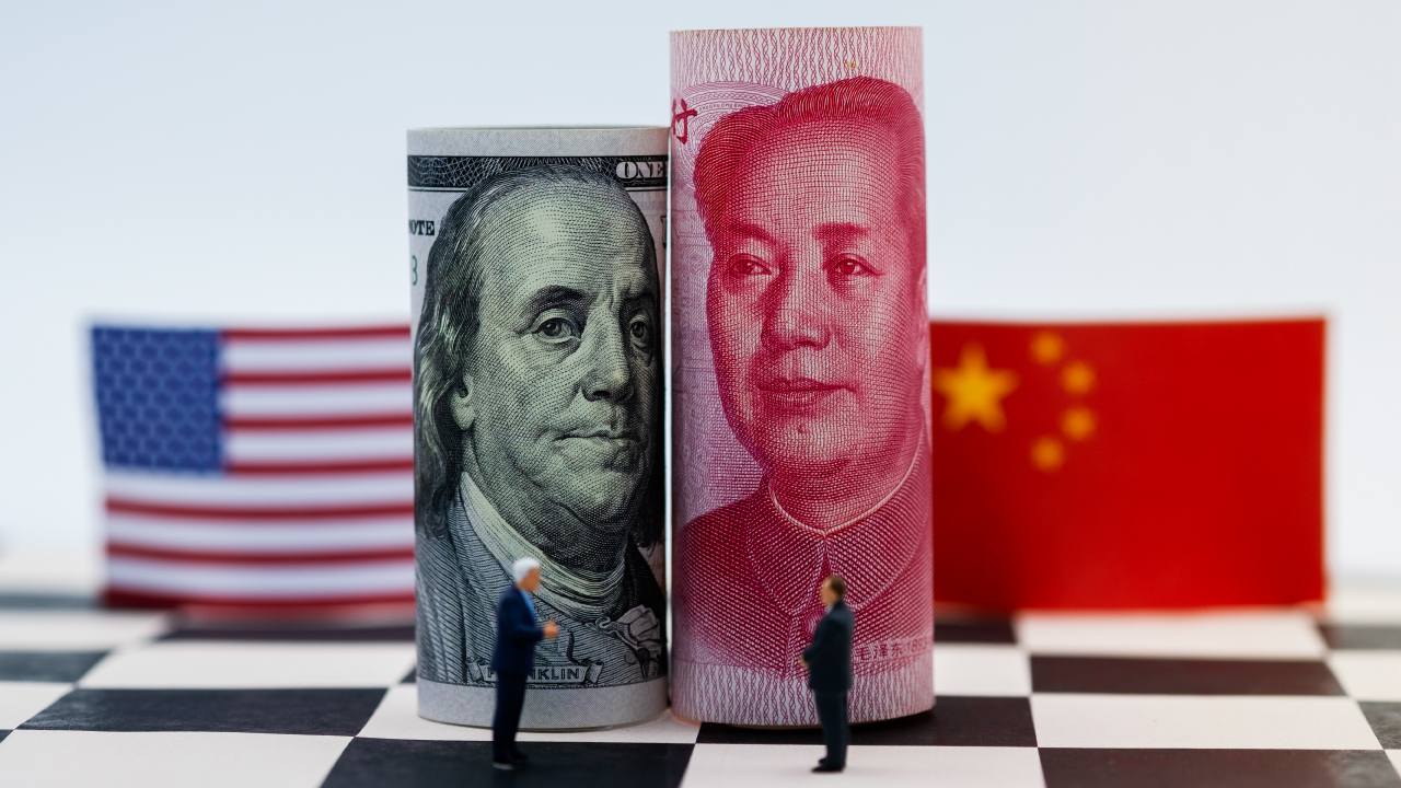 Trump y Xi Jinping firman un acuerdo comercial en un evento diplomático con banderas de fondo.